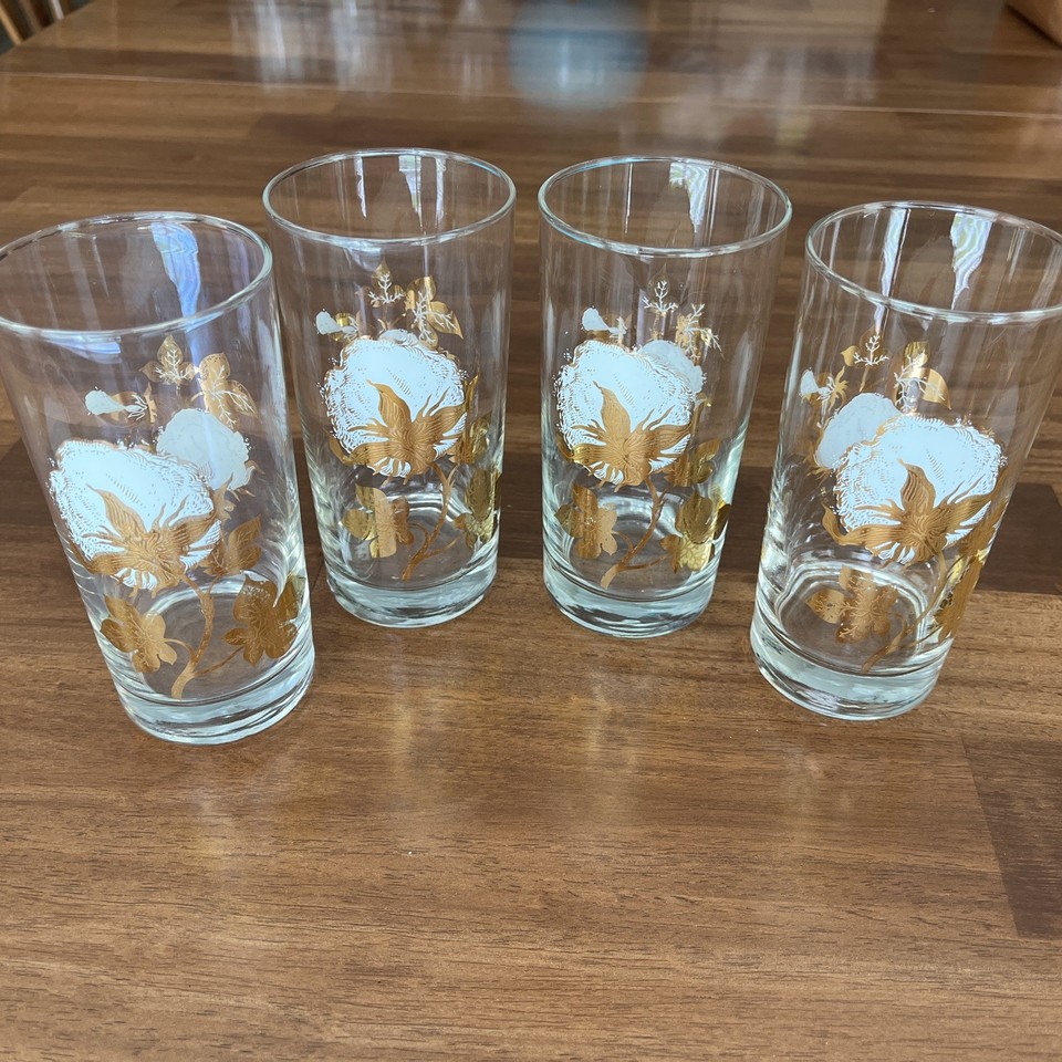 Set of 4 MCM gold-rimmed highball glasses featuring a cotton boll motif — the kind of barware that stops a dinner party conversation cold.