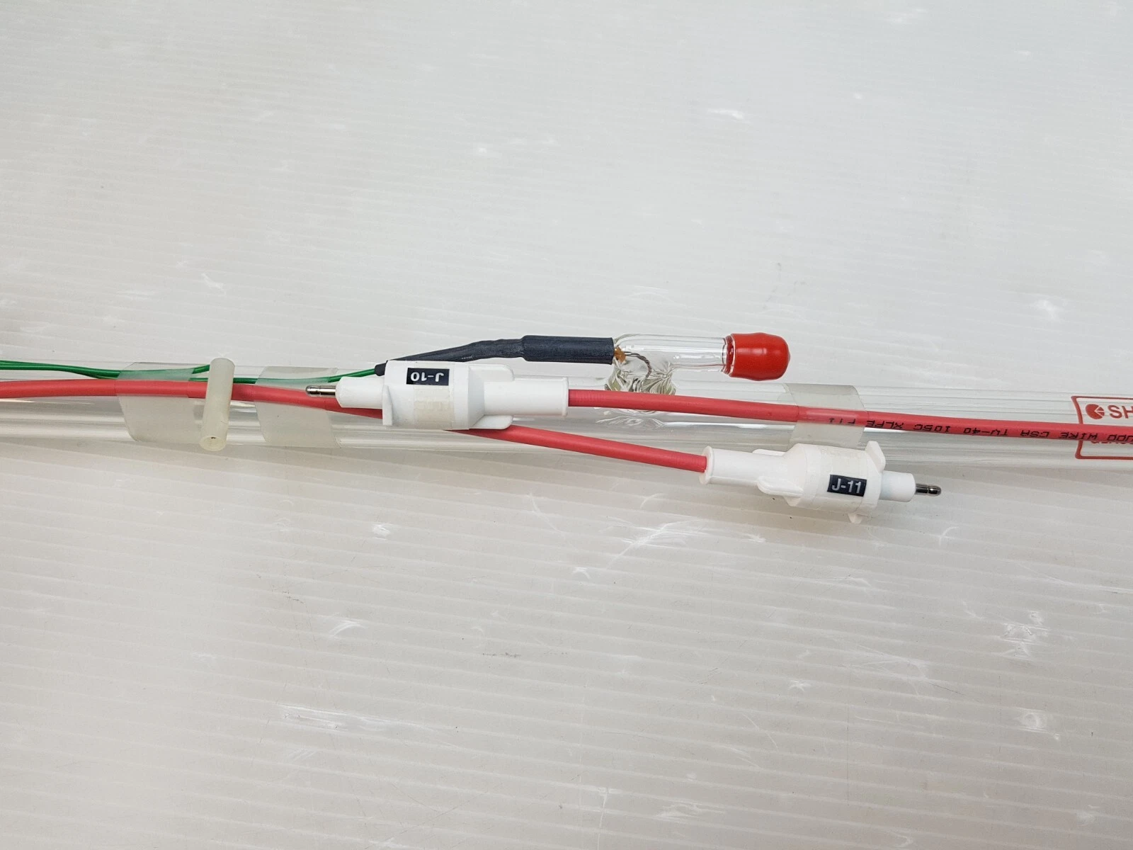 Red high-voltage leads with J-10 and J-11 connectors on the laser tube