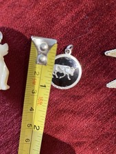 Antyczny mały srebrny wisiorek ze znakiem zodiaku byka i brązowym tłem pokropnym