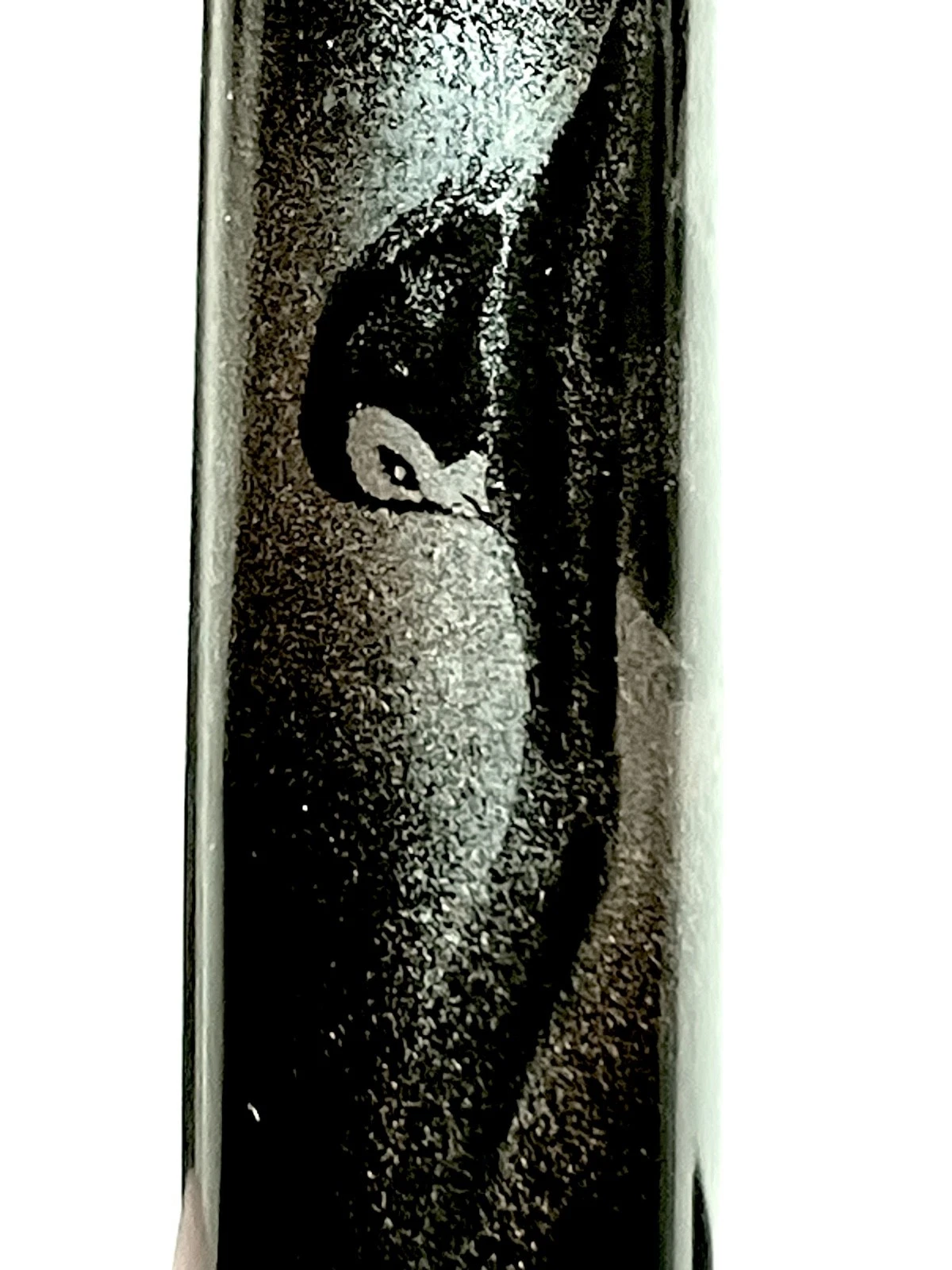Black and white vintage ink shut off fountain pen with textured barrel, featuring faint penguin silhouette against the background.