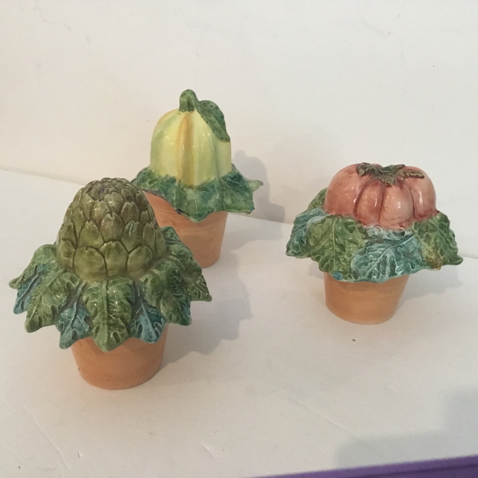 3 ceramic pots with vegetable tops.