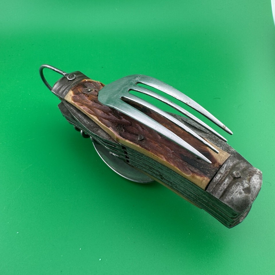 A genuine vintage 'Hobo knife' with 11 implements including a spoon and fork — the OG camping multitool with serious Victorian/early 20th-century wanderer energy.