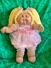 Vintage Cabbage Patch doll with long blonde hair, blue eyes and a frilly dress