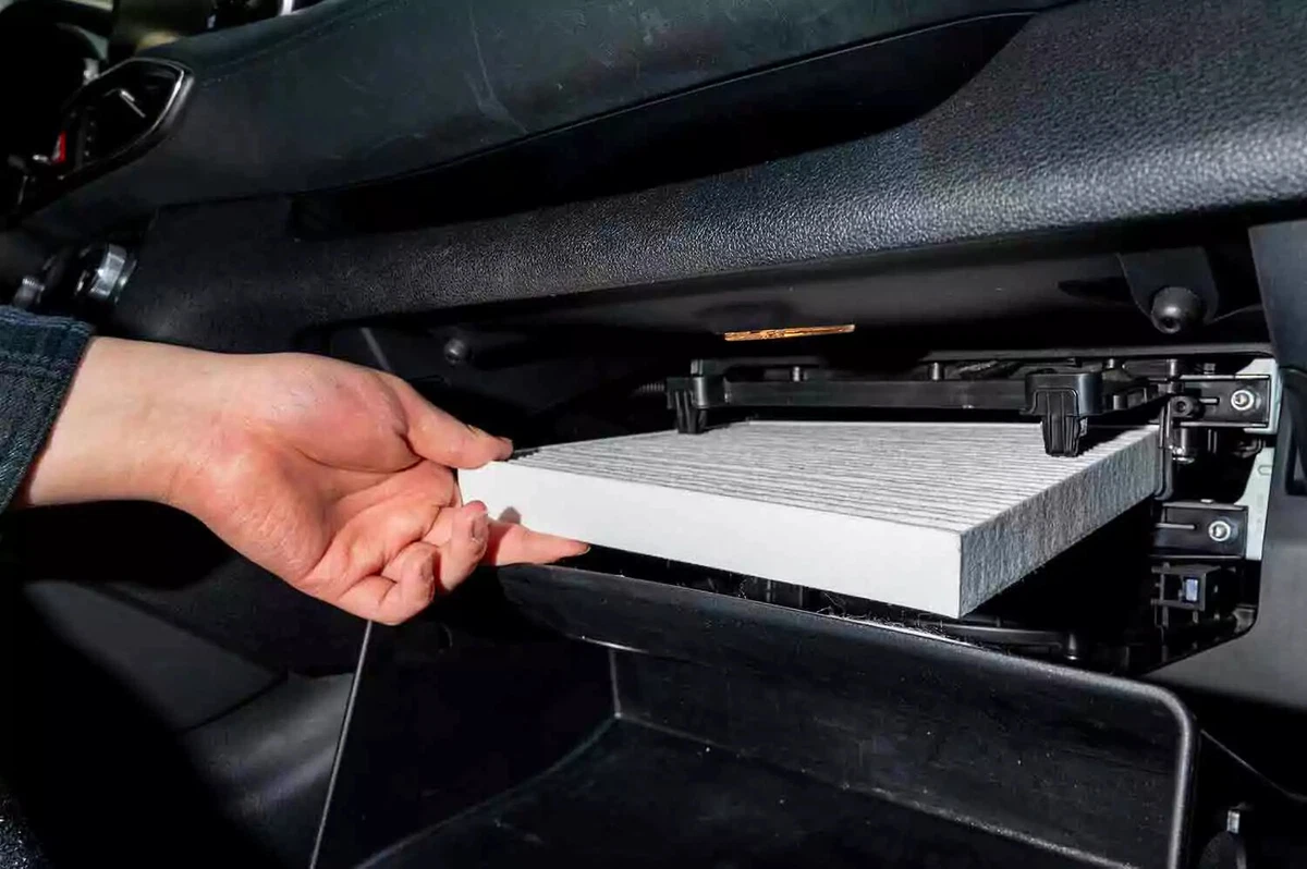 An owner replaces the cabin air filter in his vehicle’s glove compartment.