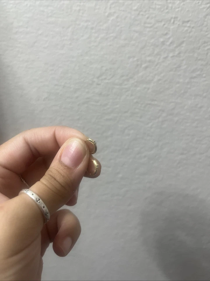 Pendientes Huggie de oro amarillo macizo de 14k con diamante pequeño en el centro Foto 3 de 4