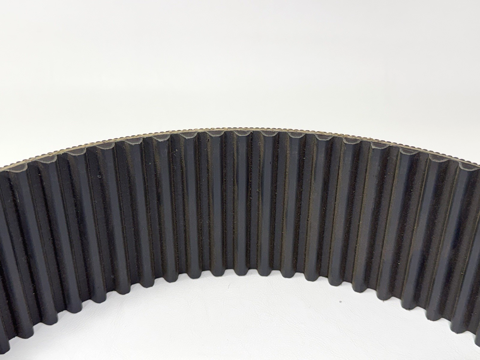 Black GATES 14MGT-994-90 poly chain belt with vertical ribbed pattern, worn white on metal side.