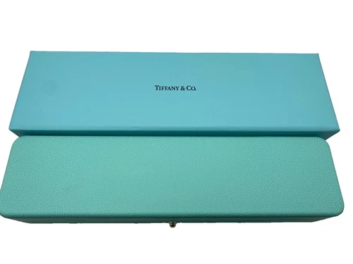 Blue leather Tiffany & Co. jewelry gift box with embossed logo and gold-tone clasp.
