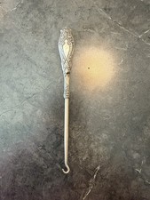 An ornate Sterling Silver button hook with a scrolled Victorian handle.