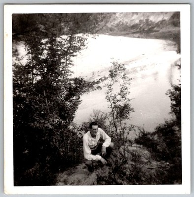 Vtg B&W Snapshot Man Crouching On River Bank Overlook Scenic Wooded Landscape