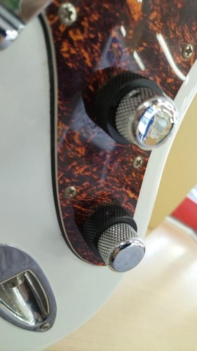 White SQUIER VATAGE electric guitar with silver hardware and dark orange-brown pickguard featuring two black knobs.
