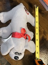 Pound puppy plush toy in gray with red ribbon as a collar