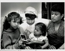 1990 Press Photo Norma Delgado and daughters view photo of dog in Springfield