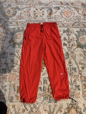 Red Nike track pants with drawstring waist athleisure