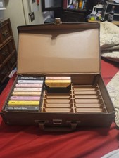 10 Old Cassette Tapes In A Carrying Case. Used case has some damage.
