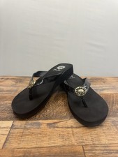 Yellow Box Fazania flip-flops, feature a glossy patent strap and logo medallion.