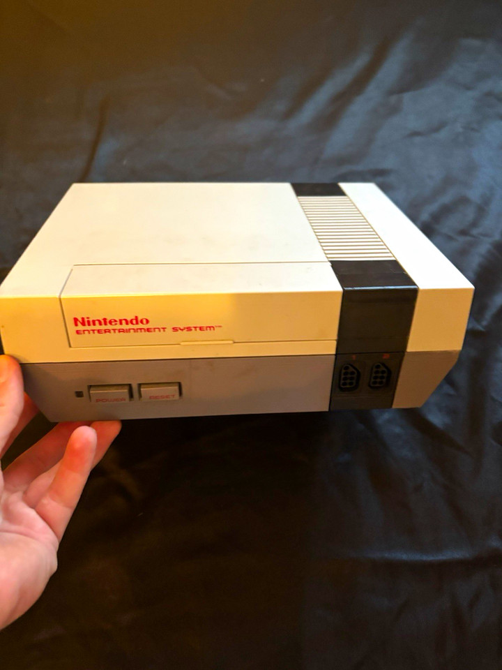 A curated NES lot with console, controllers, accessories, and original guides — feels like unearthing a time capsule from a cool older sibling's closet.