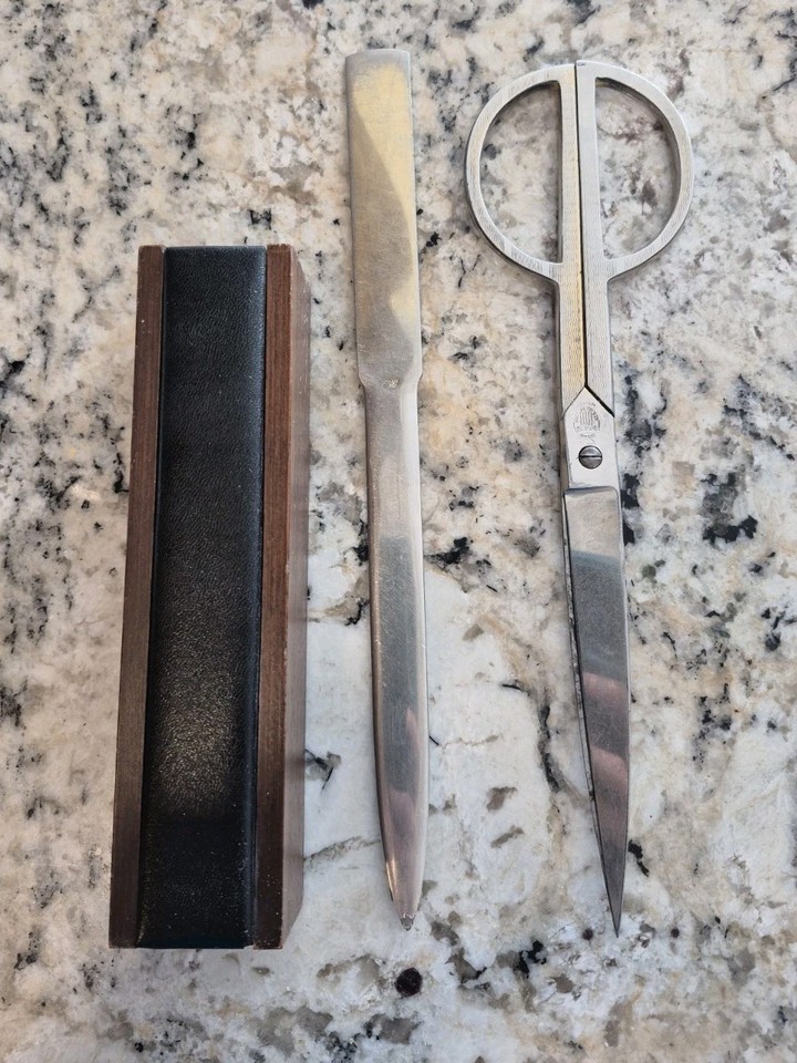 An Italian scissors-form letter opener with brass handles and a wood desk set — the kind of elegant tool that makes opening mail feel like an event.