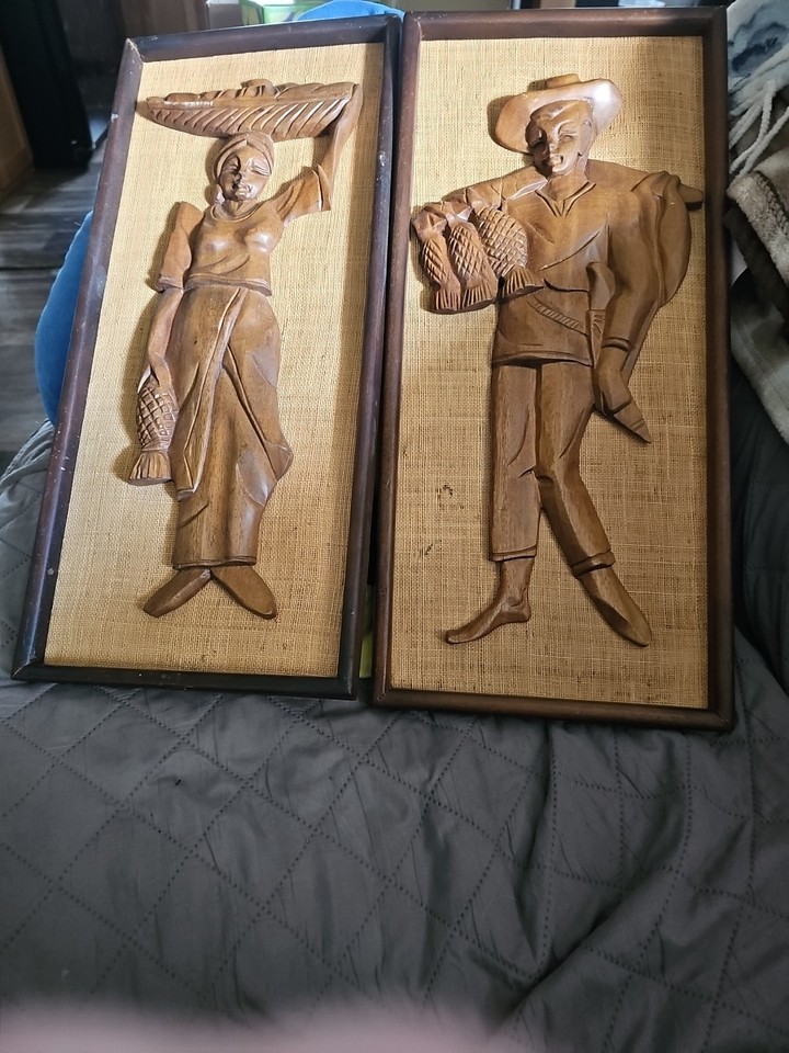 Genuine 1960s carved teak his-and-hers wall plaques — the kind of tactile, warm-toned folk art that elevates a room and sparks a conversation.