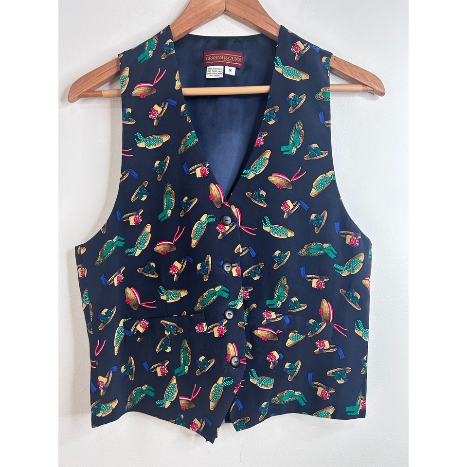 A vintage silk novelty waistcoat printed with hats — the kind of eccentric menswear statement piece that looks like it belongs on a Victorian magician or a very cool art professor.