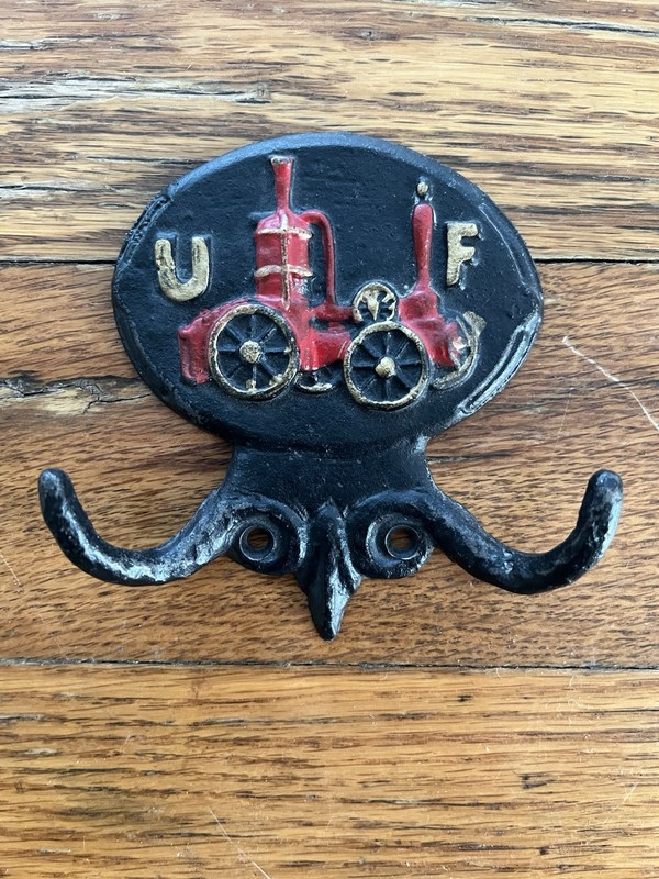 Vintage United Fireman's Insurance "Fire Mark" wall hook is crafted from cast ir