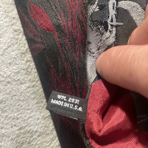 Red and black animal kingdom tie with metallic silver ring, made in U.S.A., shown close-up with white printed neck tag.