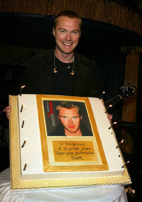 Ronan Keating stands behind a cake as he at the launch party to c- 2004 Photo 1