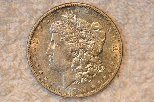 1884-S AU MORGAN DOLLAR.