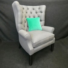 wing chair with barrel back in grey thick linen styled fabric with black legs