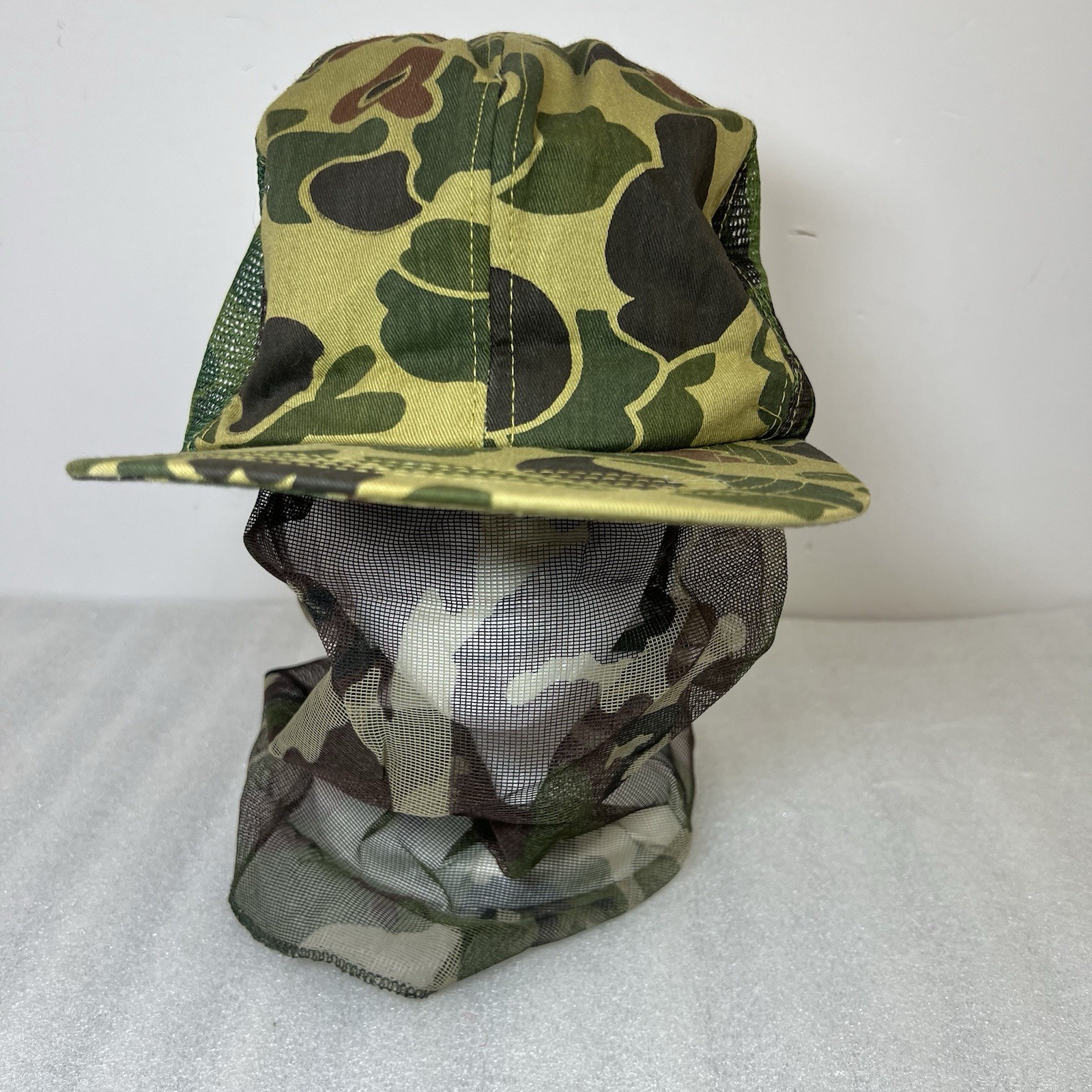 Green and brown camouflage Vtg hat with mesh front and dark green mosquito netting, size large USA made.