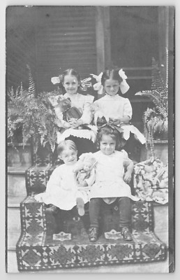 RPPC Darling Little Girls Hugging Antique Dolls, Teddy Bear on Steps Postcard
