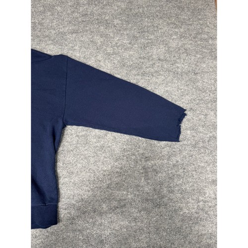 Navy blue VTG Jerzees WWII crewneck sweatshirt with visible seam and hem, laid flat on a gray carpet surface.