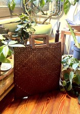 borsa intrecciata in materiale naturale con manici in legno