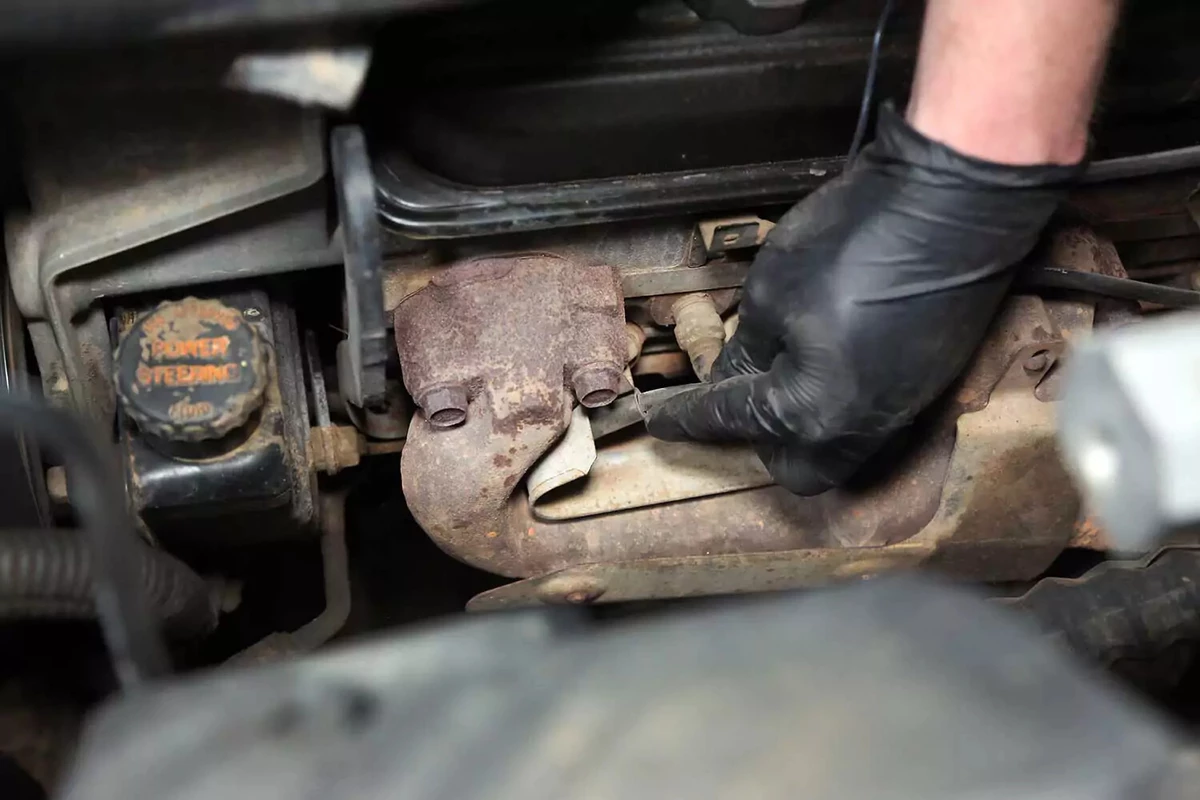 A mechanic removes a spark plug boot from the spark plug.