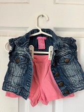 Denim vest paired with pink shorts, pockets adorned with puff ball ribbing trim