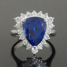 Spectacular Platinum 12.0 Ct Trillion Cut Tanzanite & 1.26 CTW Diamond Halo Ring