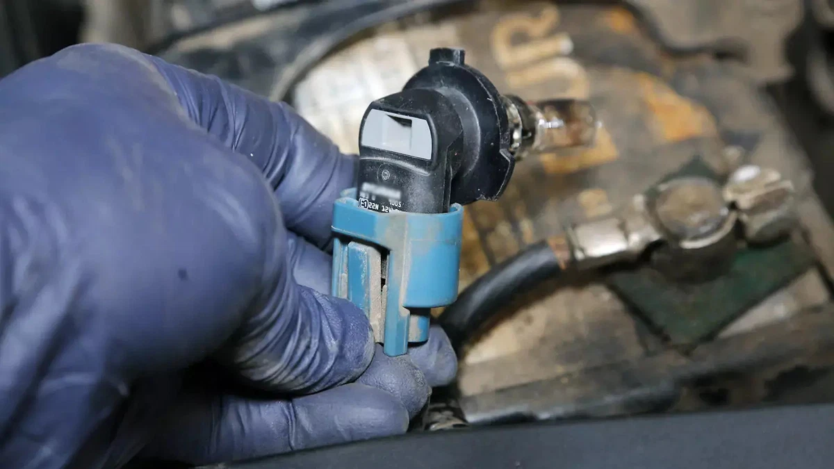 Removing a headlight bulb to be able to install a new headlight bulb.