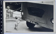 Vintage photo of the USSR, girl and boy are interested in a car, Cute children