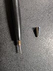 Black Eversharp mechanical pencil with silver tone trim, yellow-silver tip, and black body on textured surface.