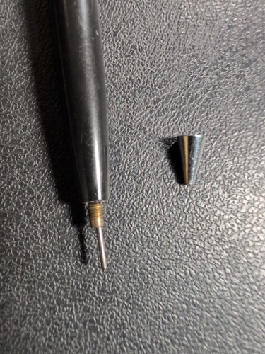 Black Eversharp mechanical pencil with silver tone trim, yellow-silver tip, and black body on textured surface.