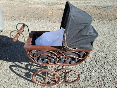 Alter Puppenwagen mit Porzellanpuppe