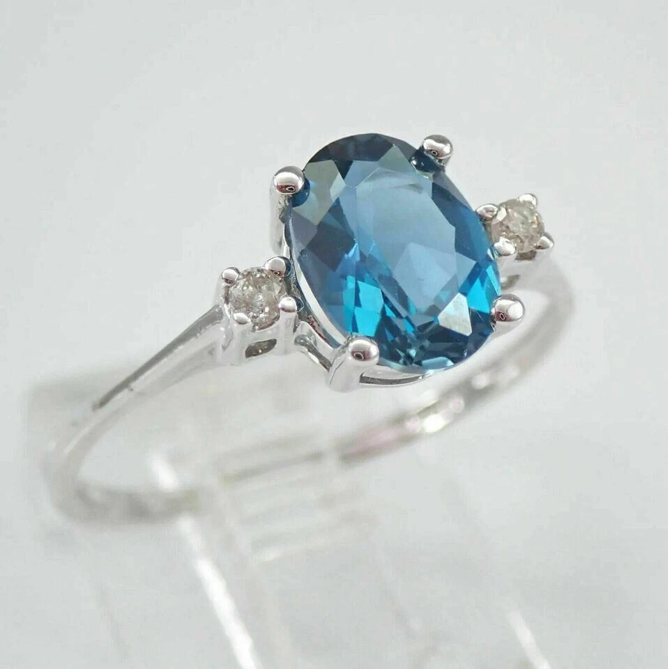 Anillo de compromiso de tres piedras con topacio azul corte ovalado de 2 quilates acabado en oro blanco de 14 quilates Foto 2 de 4
