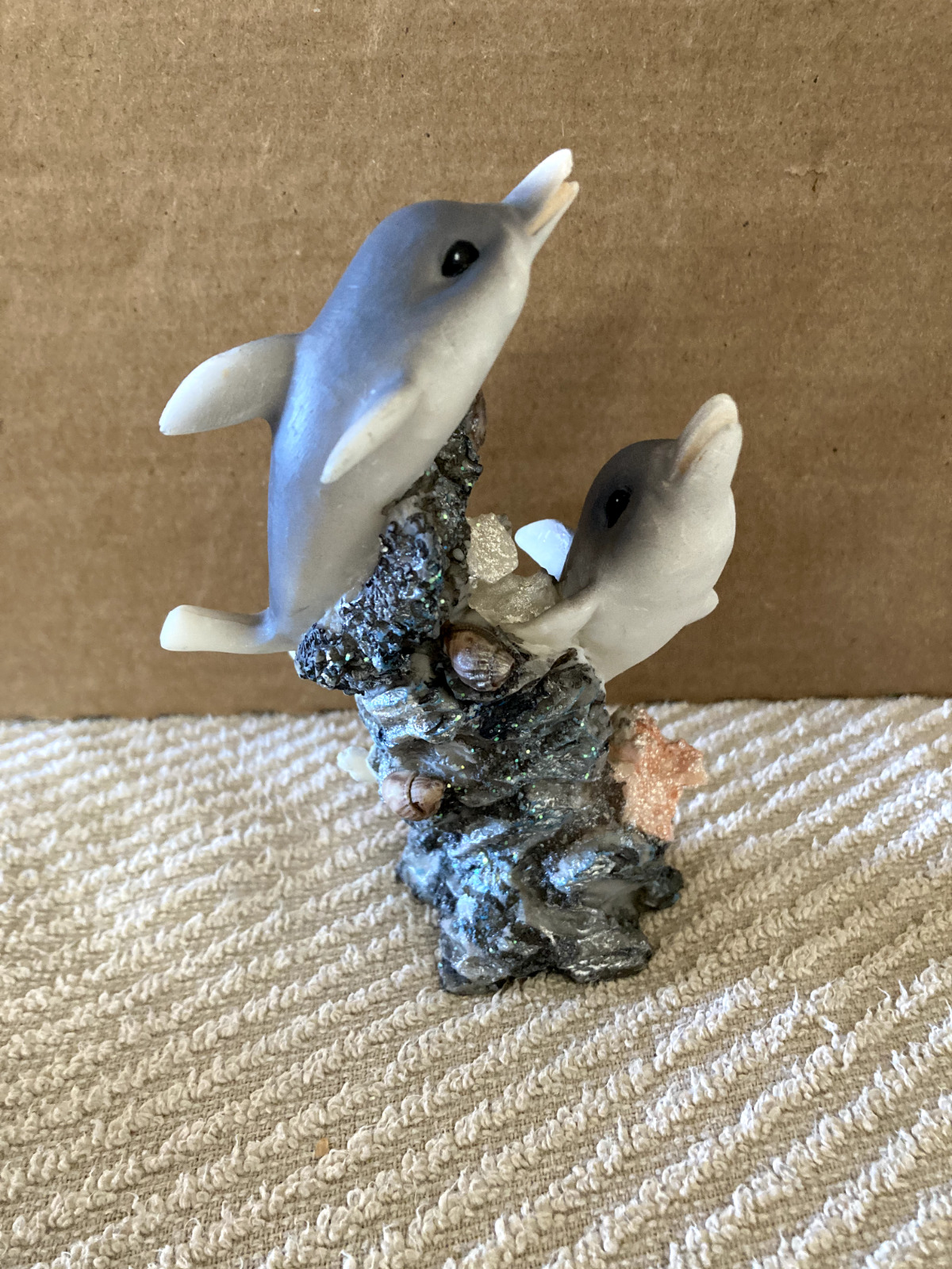 preowned dolphine figurine swimming around coral