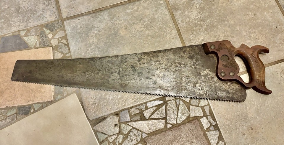 An 1887 E.C. Atkins hand saw with an ornately carved handle — less tool, more Victorian-era sculpture you can hang on a wall.