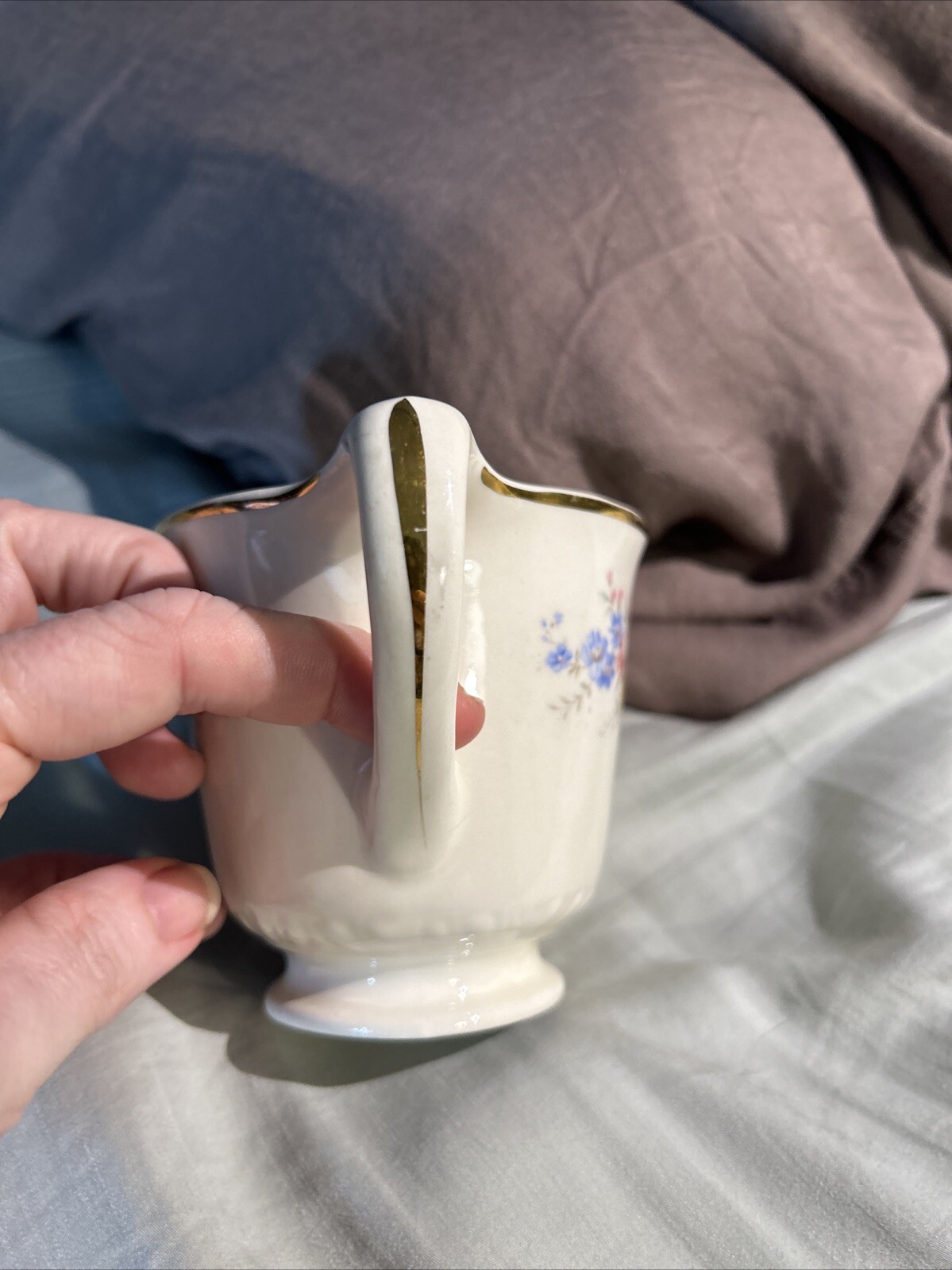 Cream ceramic mug with gold rim, floral print in blue and white, and “Made in U.S.A.” text on handle.