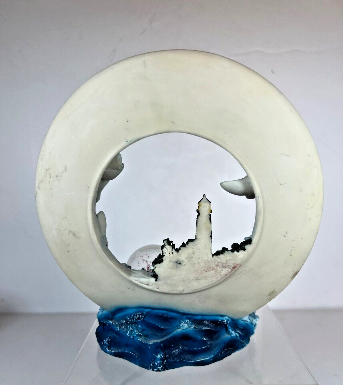 Large Ring of Dolphins swimming around a Light House