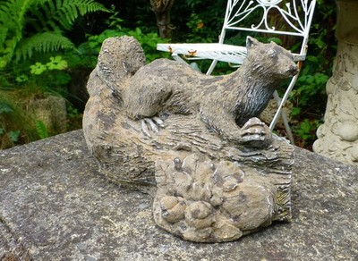 Süßes altes altes Eichhörnchen auf einem Baumstamm Eicheln Stein Garten Ornament Statue Display