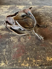 Antique hand-wrought iron Goose Neck cowboy spurs with leather straps.