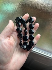 15" strand of flat wavy polished black onyx round beads, 24 beads total