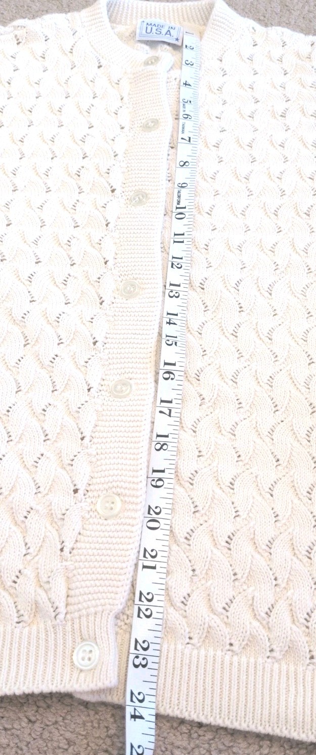 Cream knit women's long sleeve sweater with scalloped pattern, button front, and two vertical panels.