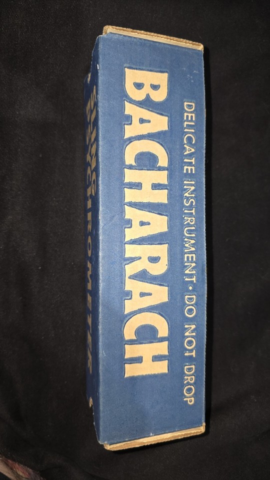 A vintage Bacharach sling psychrometer — a whirling analog humidity meter that's equal parts science class nostalgia and steampunk conversation piece.